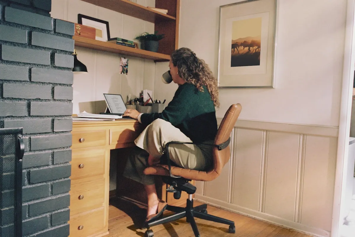 Bookkeeper working through a client's QuickBooks file at a home office desk