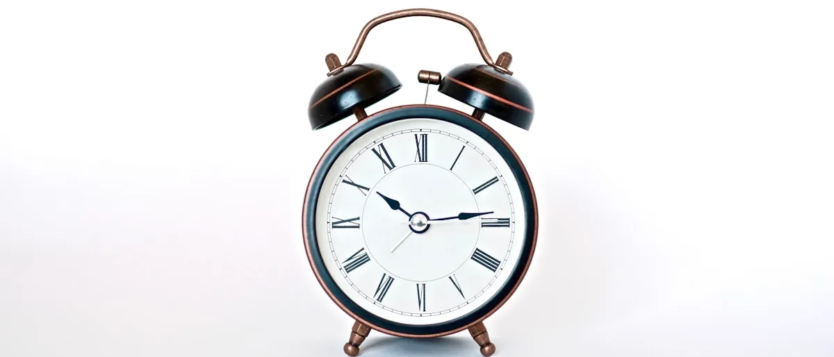A vintage-style black and copper alarm clock on a plain white background
